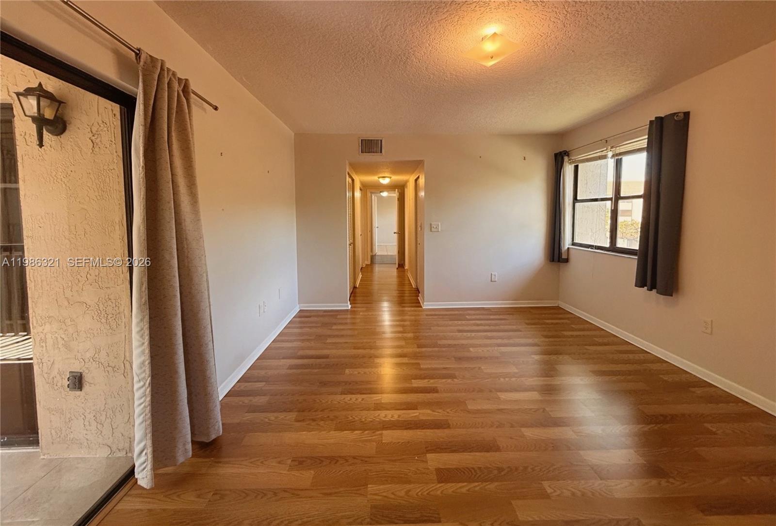 511 Ives Dairy Road, Unit 3016 Miami, FL 33179 - Photo 26 of 72 a view of an empty room with wooden floor and a window