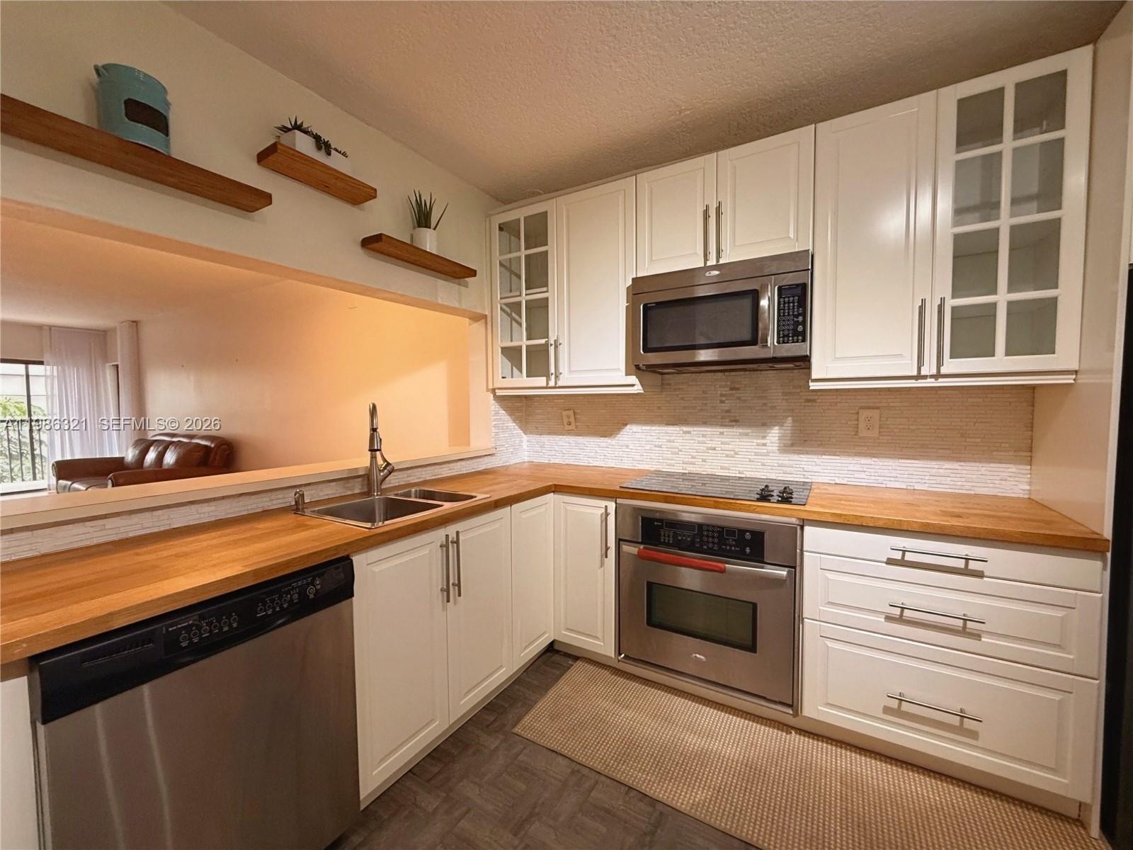 511 Ives Dairy Road, Unit 3016 Miami, FL 33179 - Photo 4 of 72 a kitchen with granite countertop a stove microwave and sink