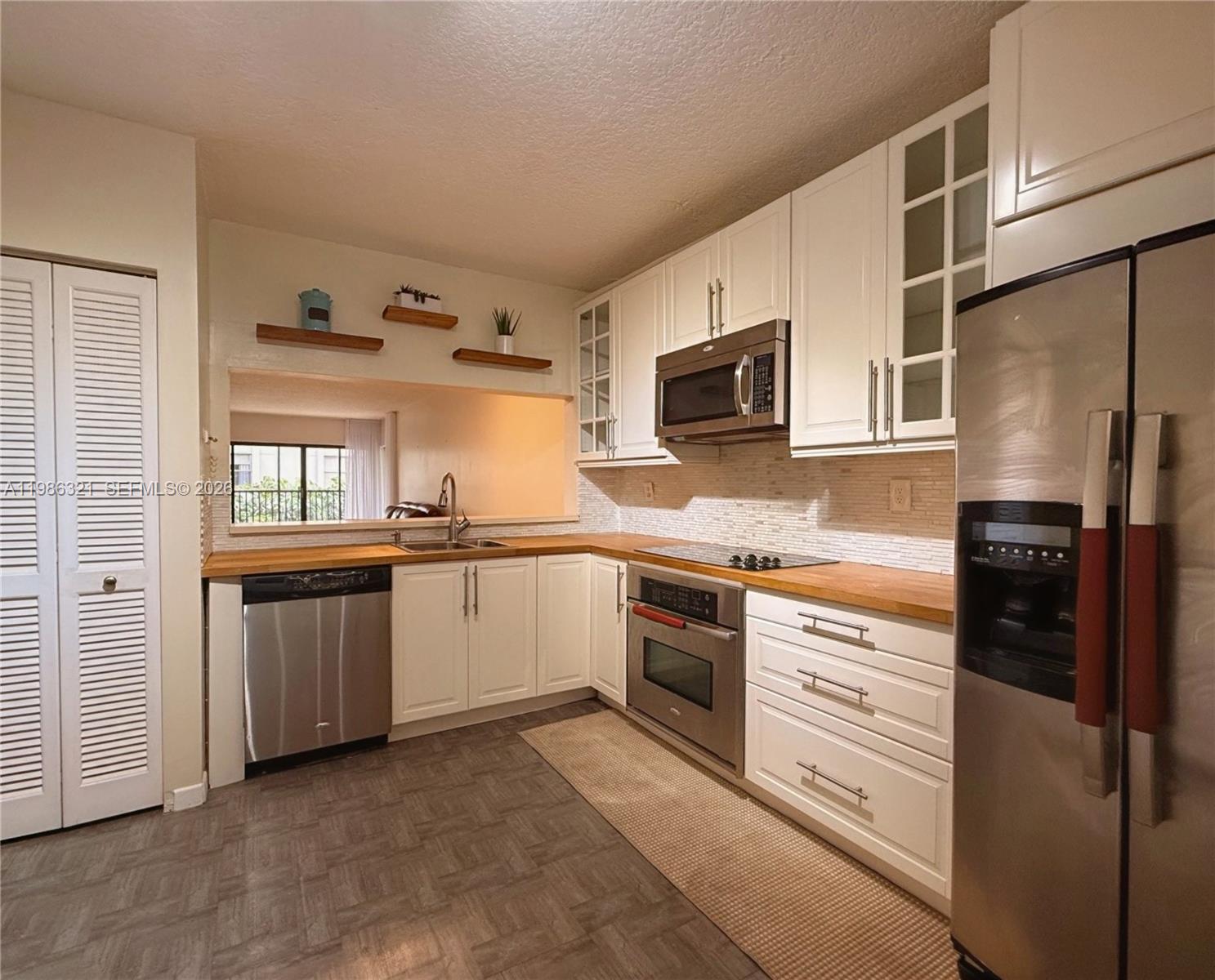 511 Ives Dairy Road, Unit 3016 Miami, FL 33179 - Photo 5 of 72 a kitchen with granite countertop a refrigerator stove and microwave