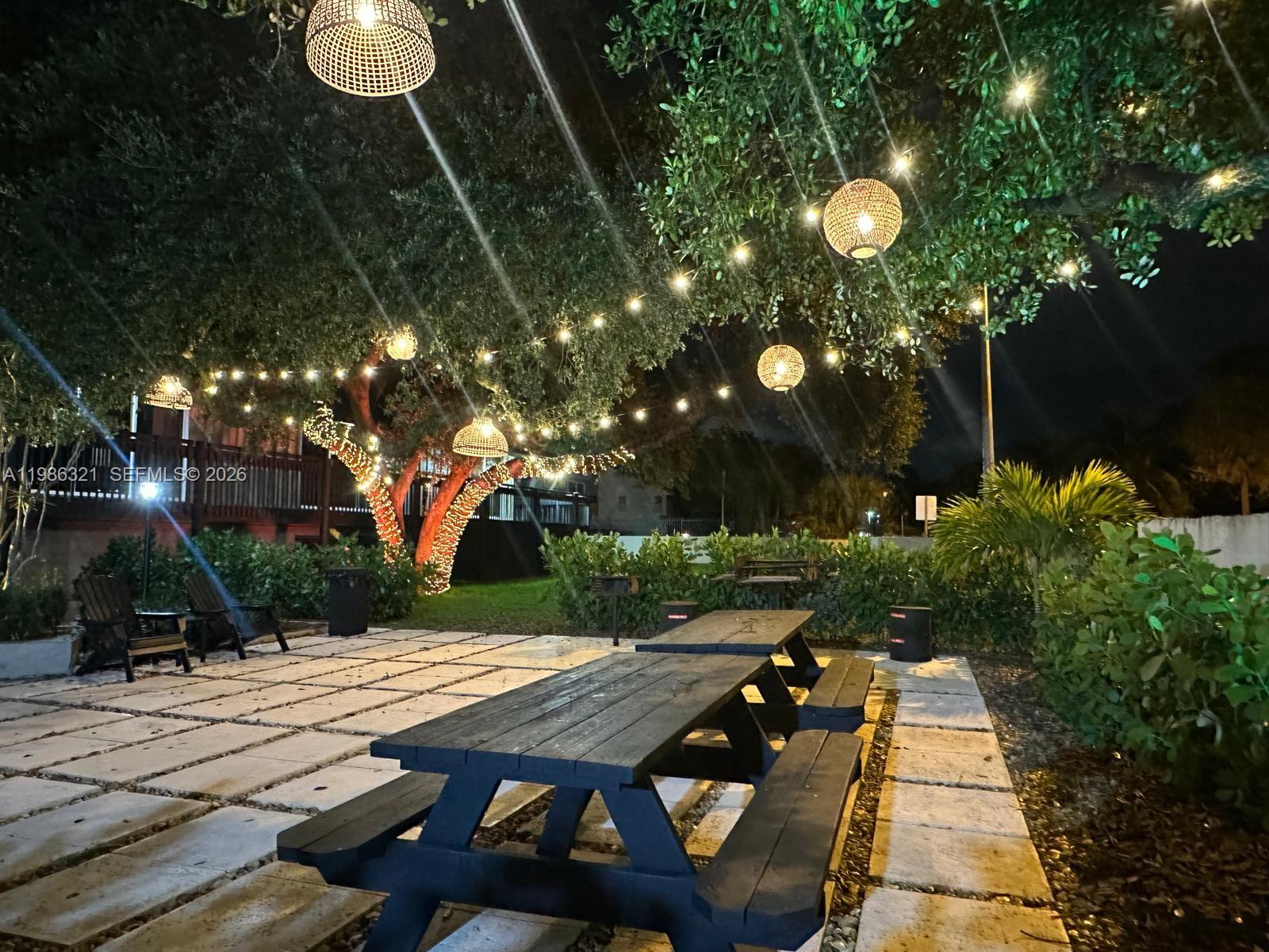 511 Ives Dairy Road, Unit 3016 Miami, FL 33179 - Photo 58 of 72 a view of backyard with table and chairs and potted plants