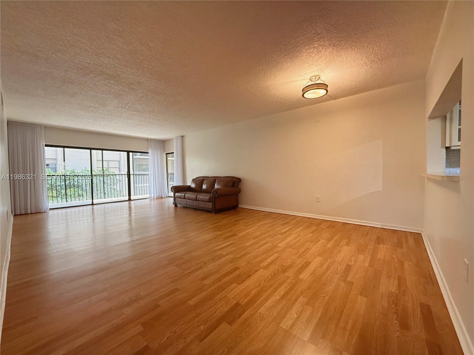 511 Ives Dairy Road, Unit 3016 Miami, FL 33179 - Photo 6 of 72 a view of empty room with wooden floor and fan