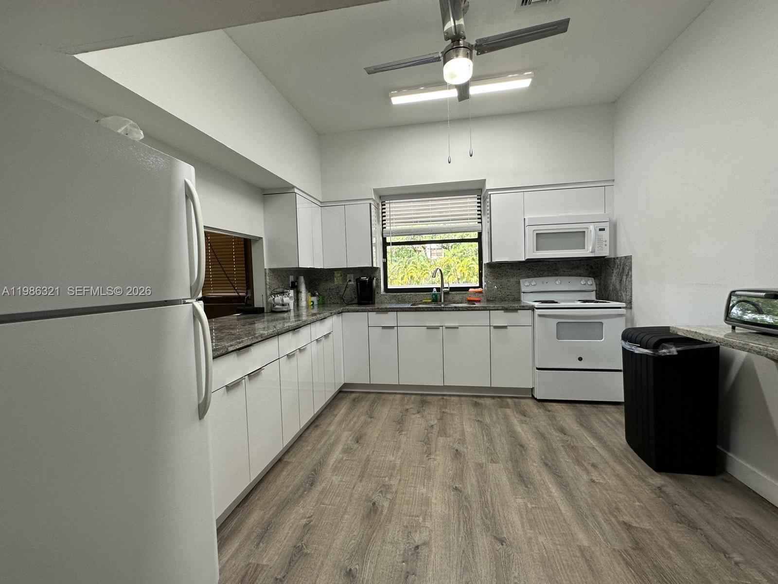 511 Ives Dairy Road, Unit 3016 Miami, FL 33179 - Photo 67 of 72 a large kitchen with cabinets wooden floor and stainless steel appliances