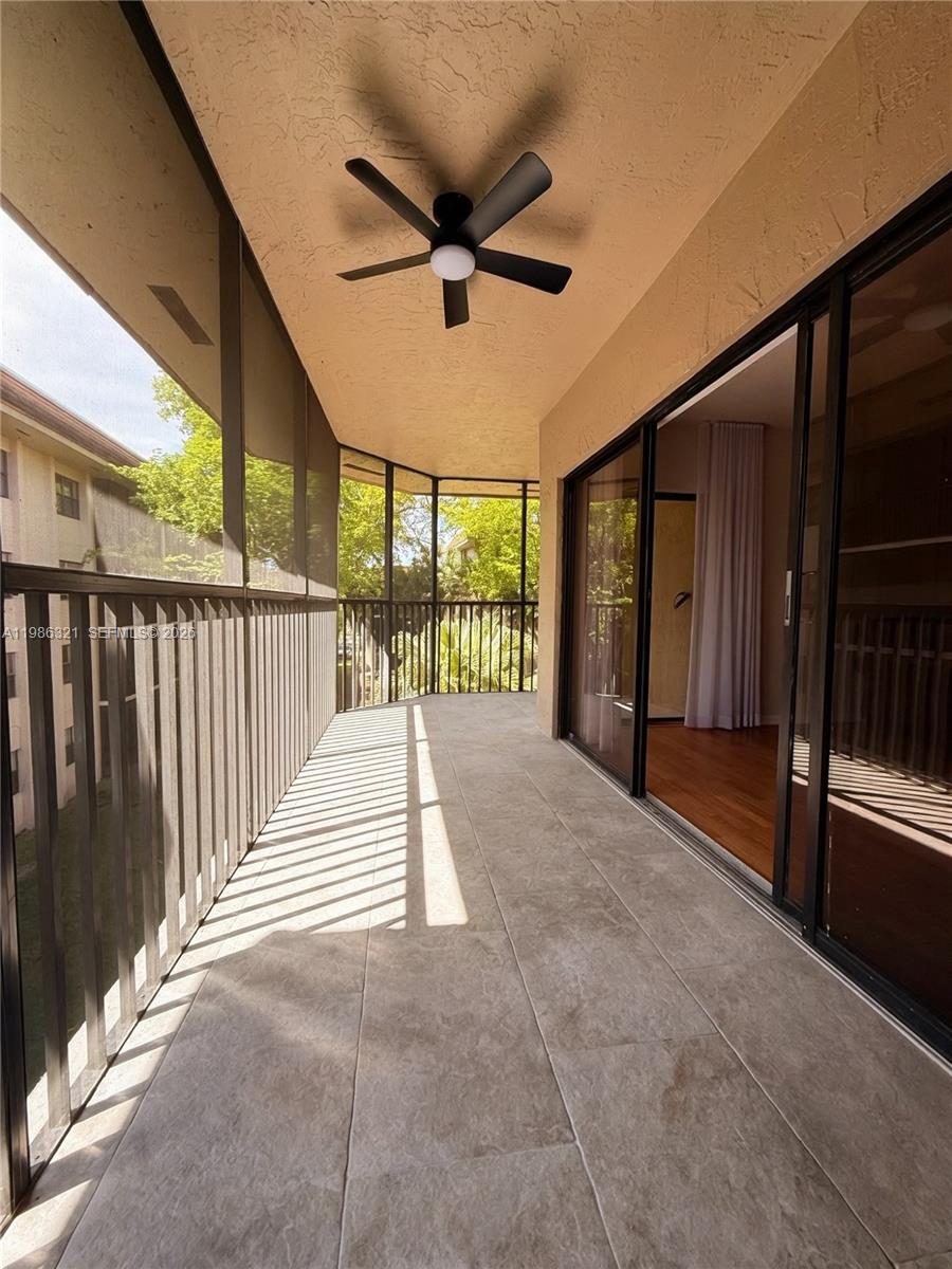 511 Ives Dairy Road, Unit 3016 Miami, FL 33179 - Photo 9 of 72 a view of a porch with wooden floor and a ceiling fan