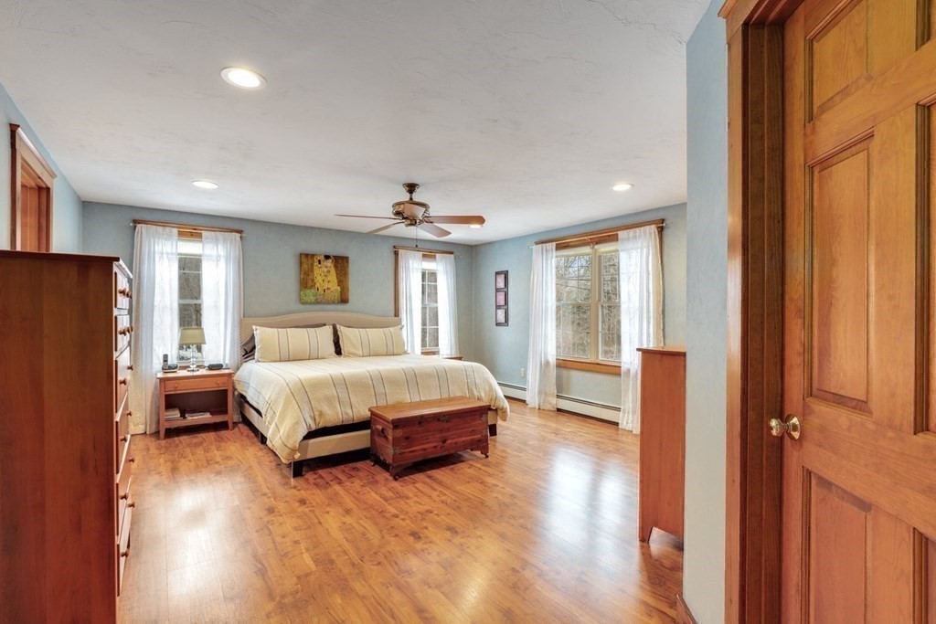 70 R Milk Street Blackstone, MA 01504 - Photo 18 of 40 a spacious bedroom with a large bed and wooden floor