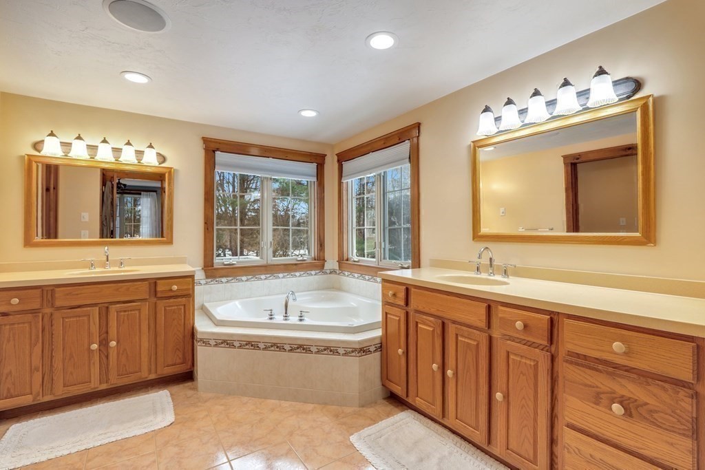 70 R Milk Street Blackstone, MA 01504 - Photo 21 of 40 a spacious bathroom with double vanity sinks a large mirror and a bathtub
