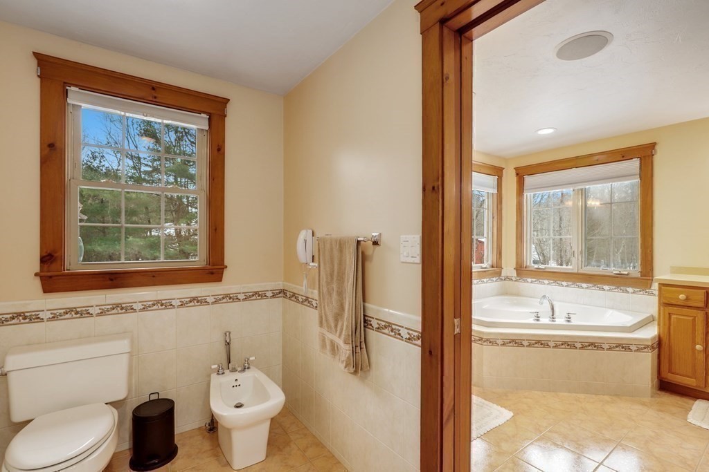 70 R Milk Street Blackstone, MA 01504 - Photo 22 of 40 a bathroom with a granite countertop toilet a sink and a bathtub