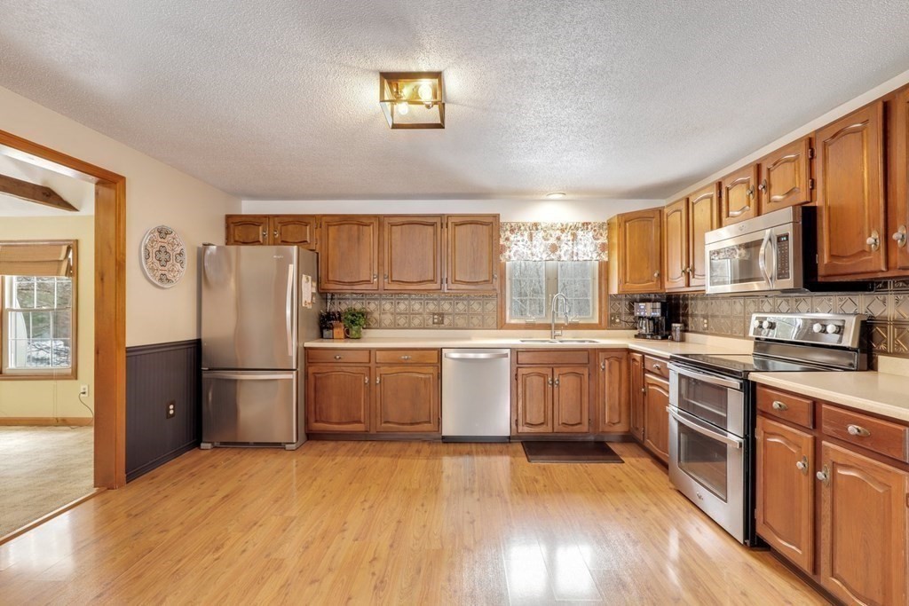 70 R Milk Street Blackstone, MA 01504 - Photo 6 of 40 a kitchen with a white cabinets a sink a window and stainless steel appliances