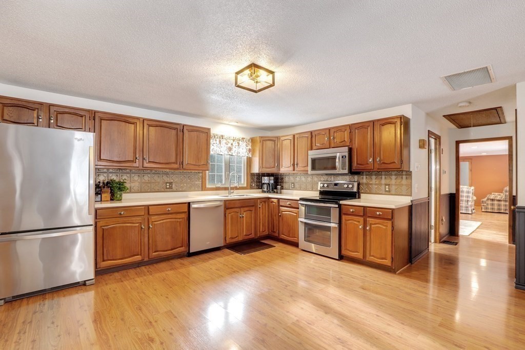 70 R Milk Street Blackstone, MA 01504 - Photo 7 of 40 a kitchen with granite countertop stainless steel appliances and wooden cabinets