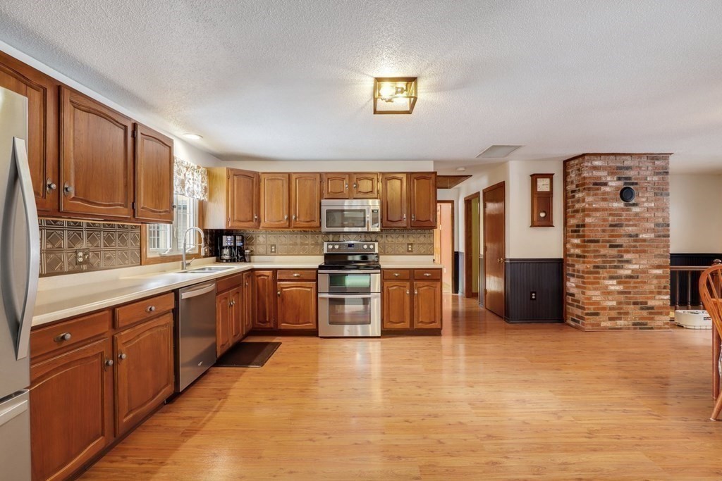 70 R Milk Street Blackstone, MA 01504 - Photo 8 of 40 a kitchen with stainless steel appliances a refrigerator and wooden cabinets