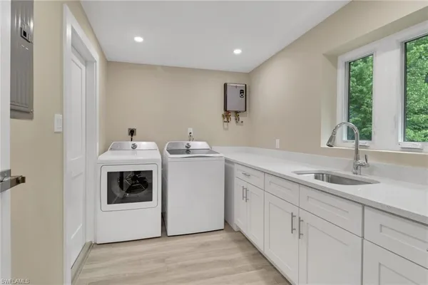a view of a kitchen with a sink and dishwasher with wooden floor