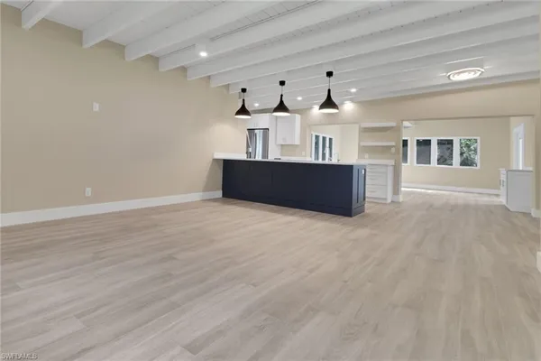 a living room with kitchen furniture and a wooden floor