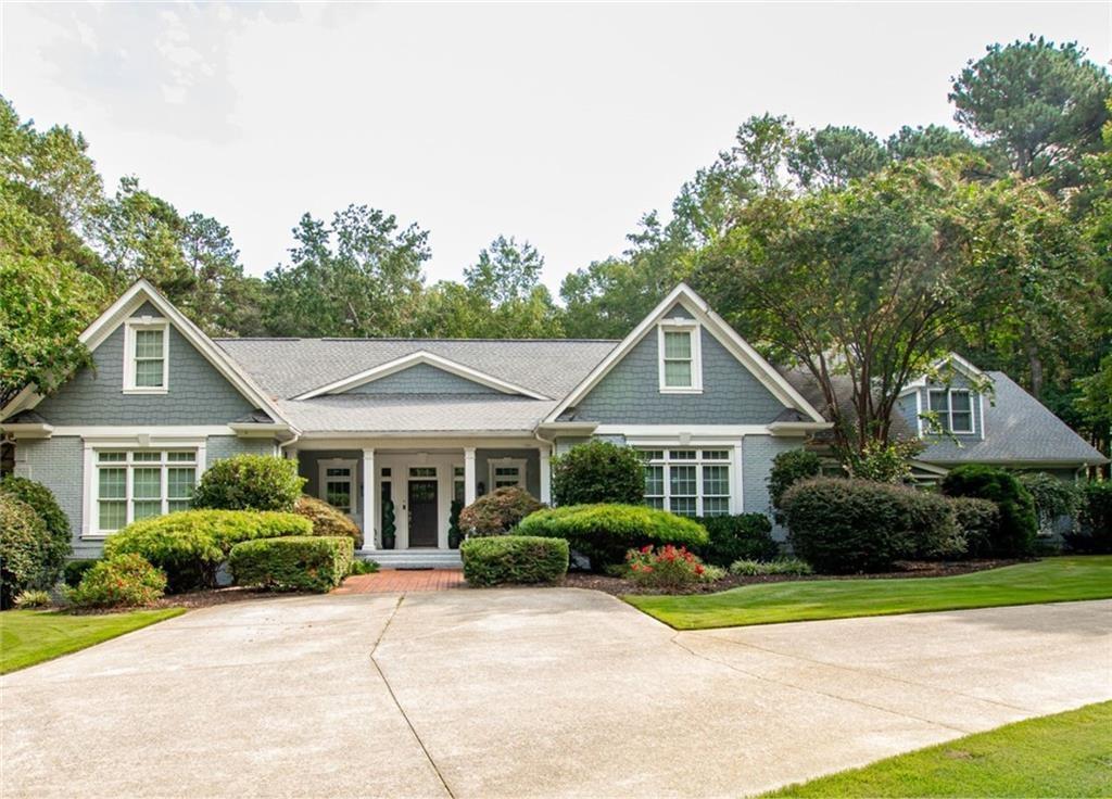 a front view of a house with a yard and potted plants