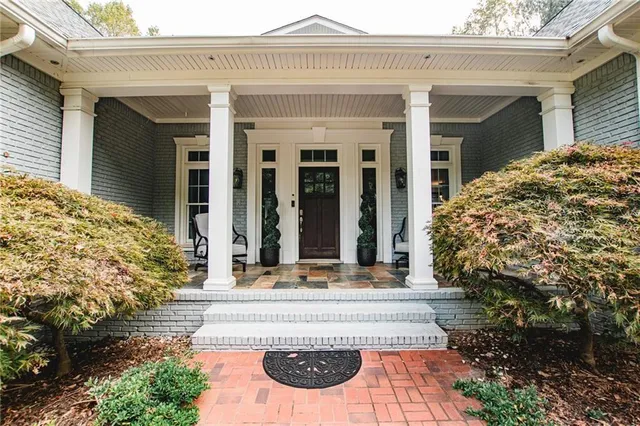a view of an empty room with wooden floor fireplace and a window