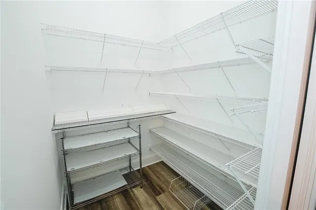 a backyard of a house with large trees and plants