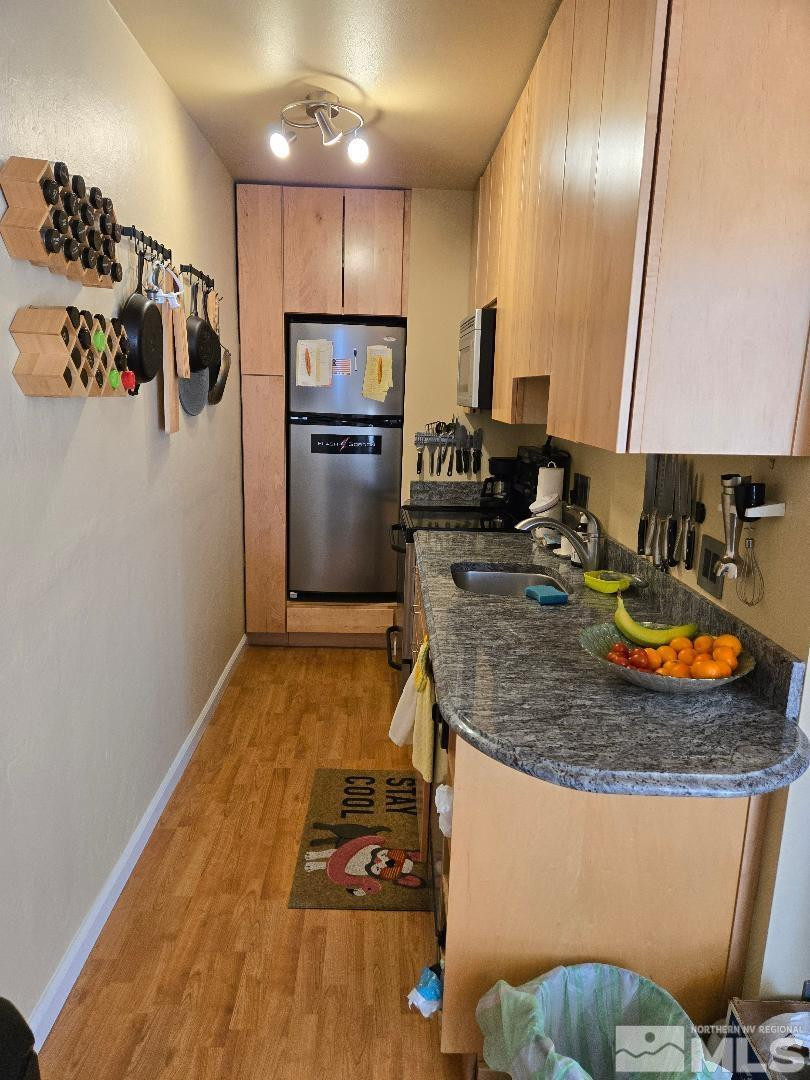 a kitchen with stainless steel appliances granite countertop a refrigerator and a stove