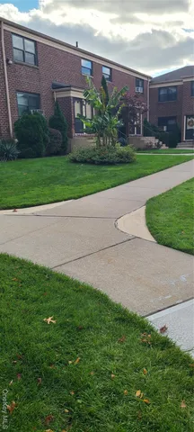 a view of a house with a yard and a large parking space