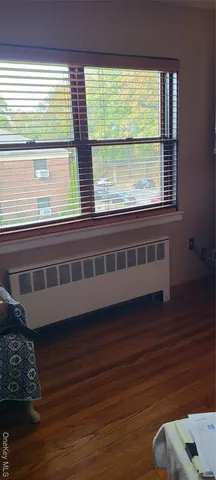 a view of a room with wooden floor and a window