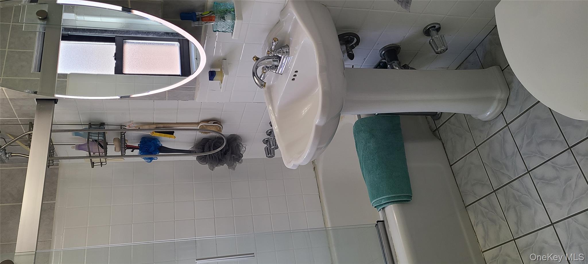 73-54 Springfield Boulevard, Unit 54A2 Queens, NY 11364 - Photo 8 of 11 a bathroom with a sink mirror and toilet