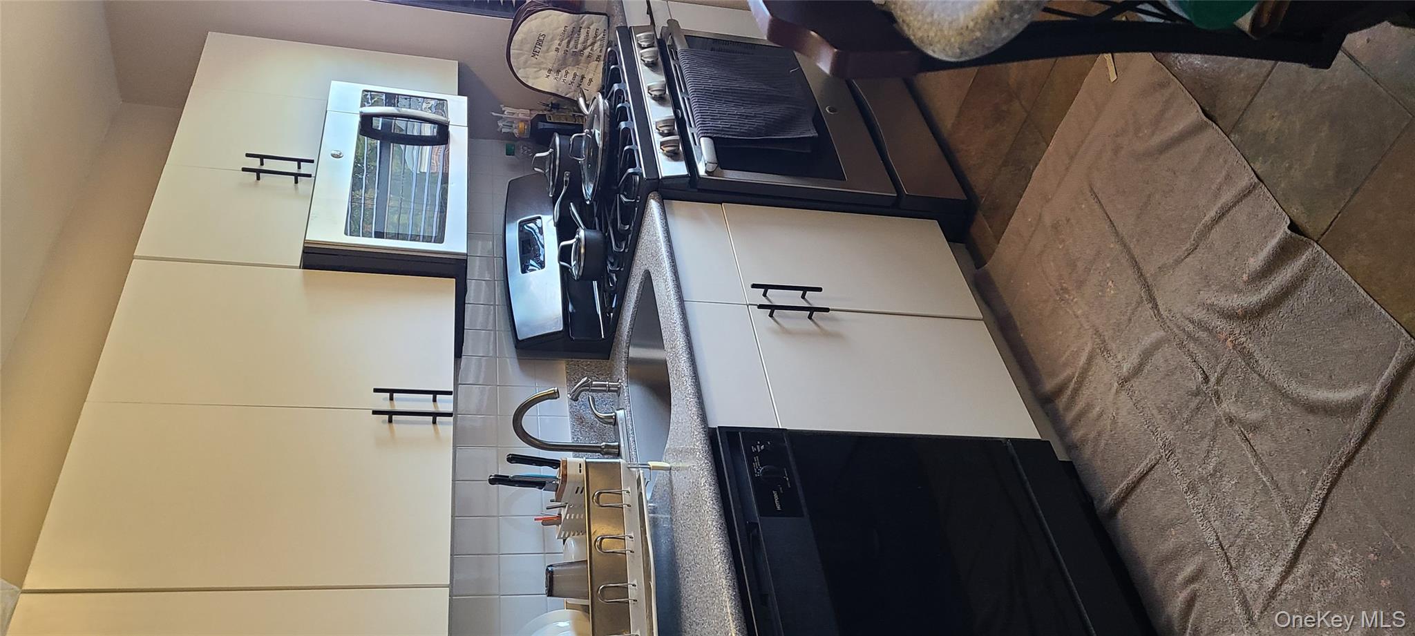 73-54 Springfield Boulevard, Unit 54A2 Queens, NY 11364 - Photo 9 of 11 a kitchen with stainless steel appliances granite countertop a sink and a stove