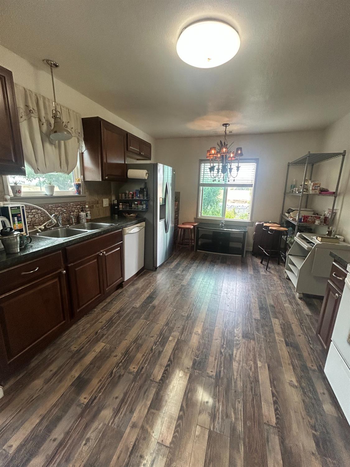 313 East Sacramento Street Coalinga, CA 93210 - Photo 12 of 23 a kitchen with stainless steel appliances granite countertop a stove and a wooden floors