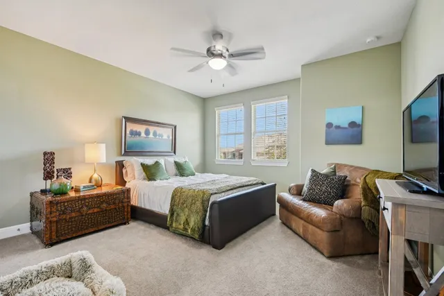 a spacious bedroom with a bed couch and window