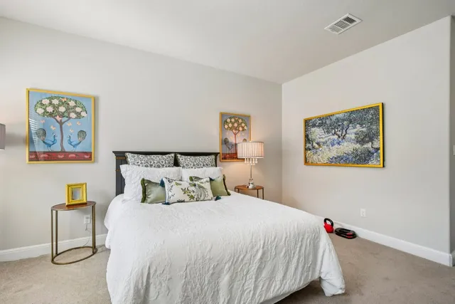 a bedroom with a bed and a painting on the wall