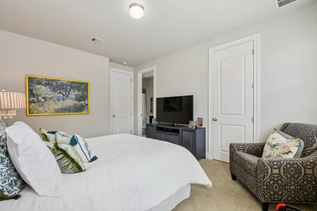 a bedroom with furniture and a flat screen tv