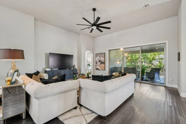 a living room with furniture a large window and a flat screen tv