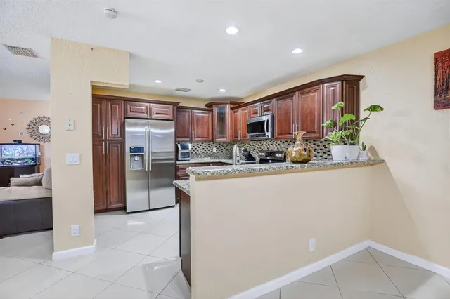 a kitchen with stainless steel appliances granite countertop a refrigerator and a sink