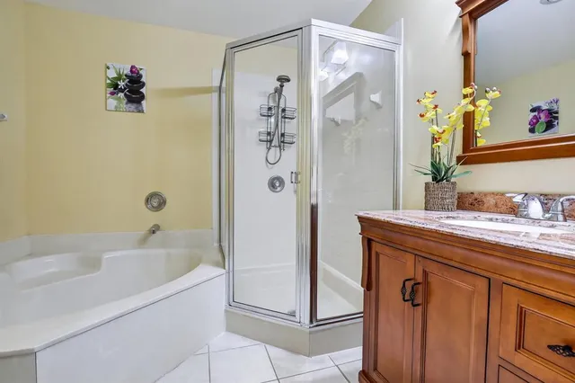 a bathroom with a granite countertop shower a sink and a mirror