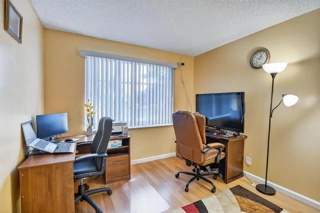 a view of a workspace with furniture and a window