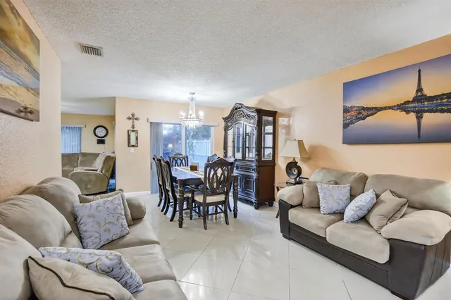 a living room with furniture and a dining table with kitchen countertops