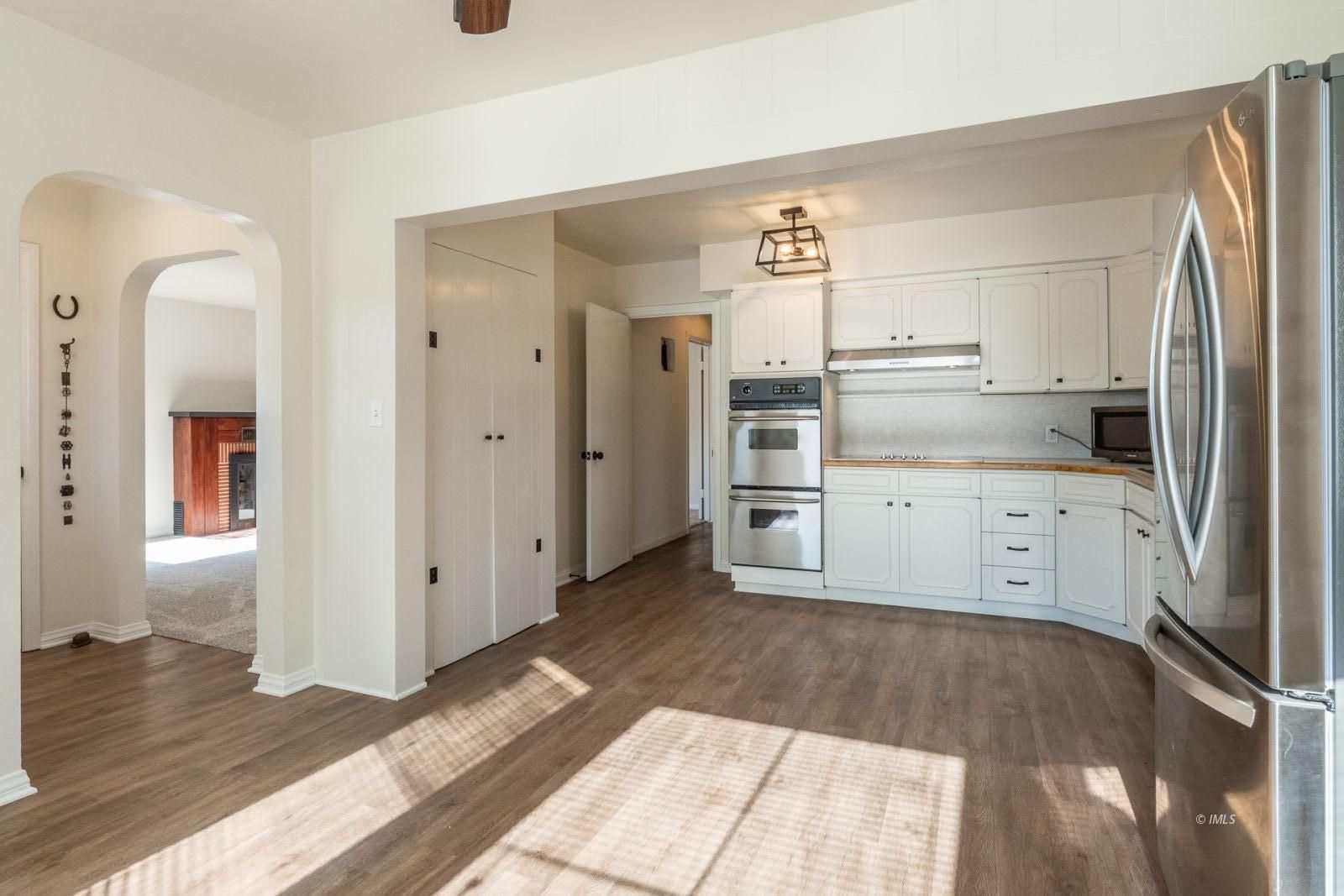 317 West Main Street Independence, CA 93526 - Photo 6 of 33 a kitchen with white cabinets and wooden floor