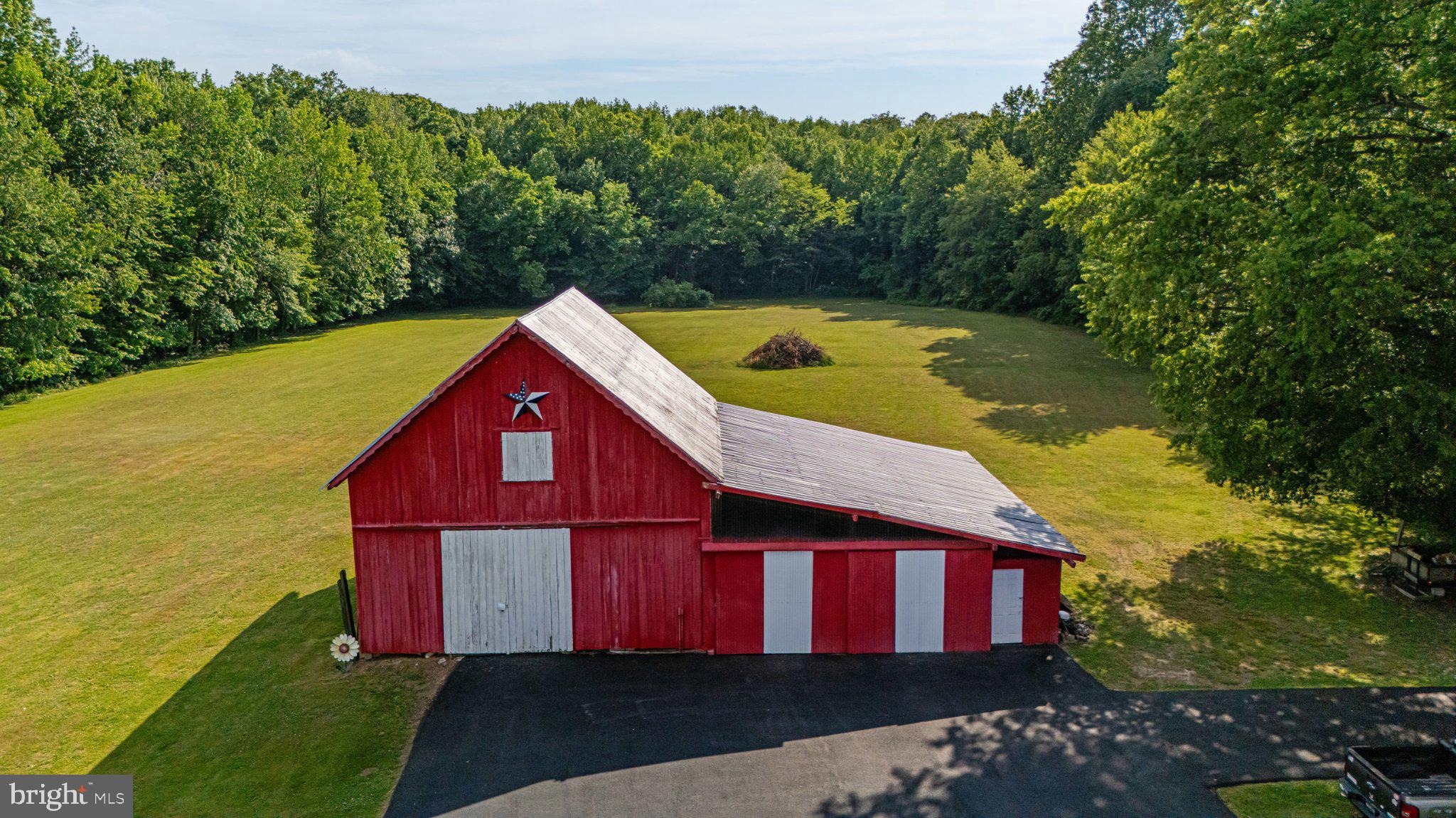 310 Dogtown Road Townsend, DE 19734 - Photo 37 of 43 Charming red barn amidst lush greenery.