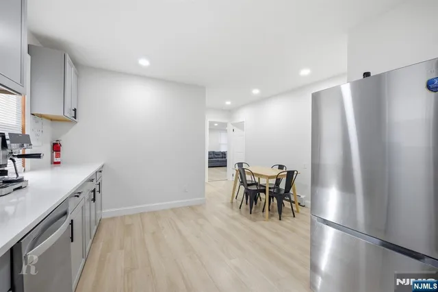 a kitchen with stainless steel appliances granite countertop a refrigerator and a stove top oven