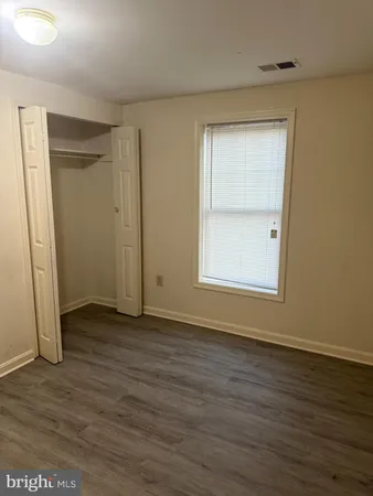 an empty room with wooden floor and a window
