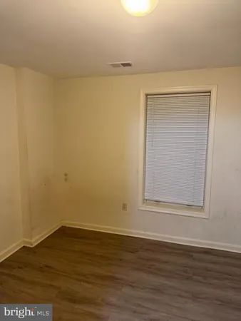 a view of a small space with wooden floor and a window