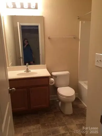 a bathroom with a sink vanity and toilet