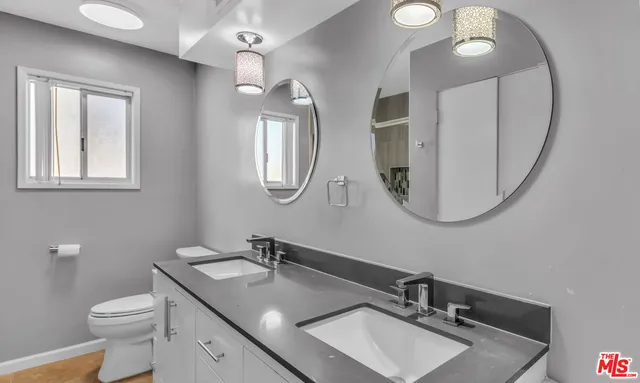 a bathroom with a toilet a sink a mirror and vanity