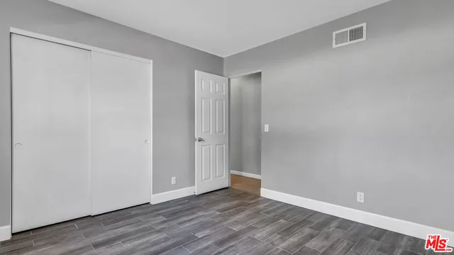 a view of an empty room with wooden floor