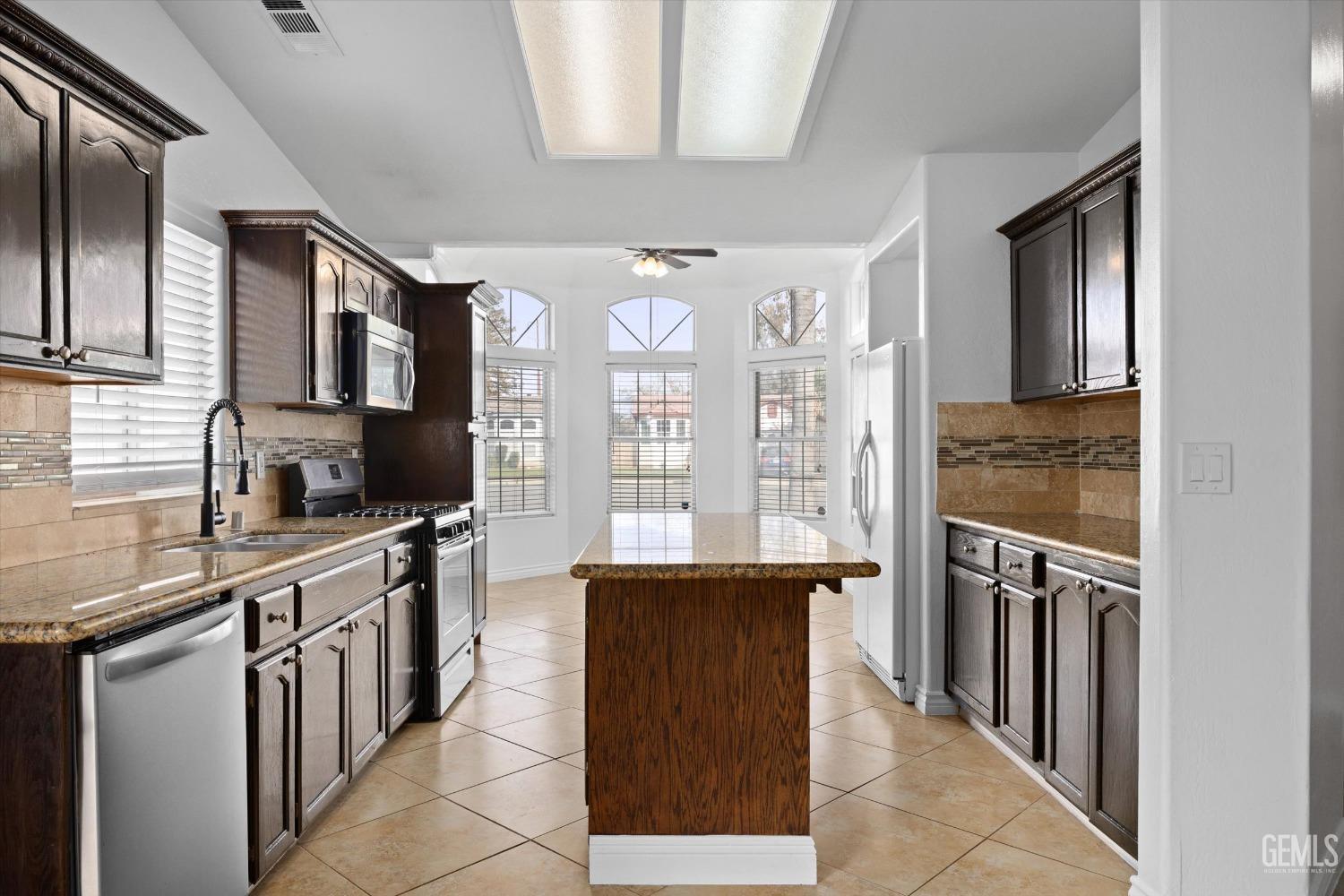 Undisclosed Address Bakersfield, CA 93312 - Photo 16 of 38 a kitchen with stainless steel appliances granite countertop a sink stove and refrigerator