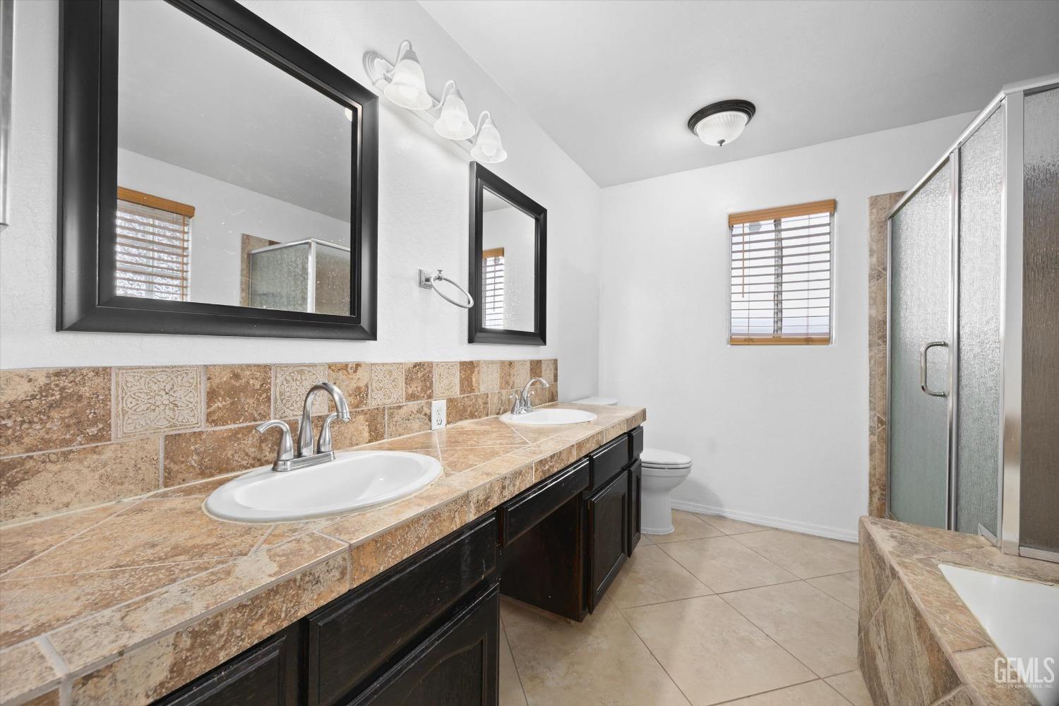 Undisclosed Address Bakersfield, CA 93312 - Photo 23 of 38 a bathroom with a granite countertop sink a mirror and a