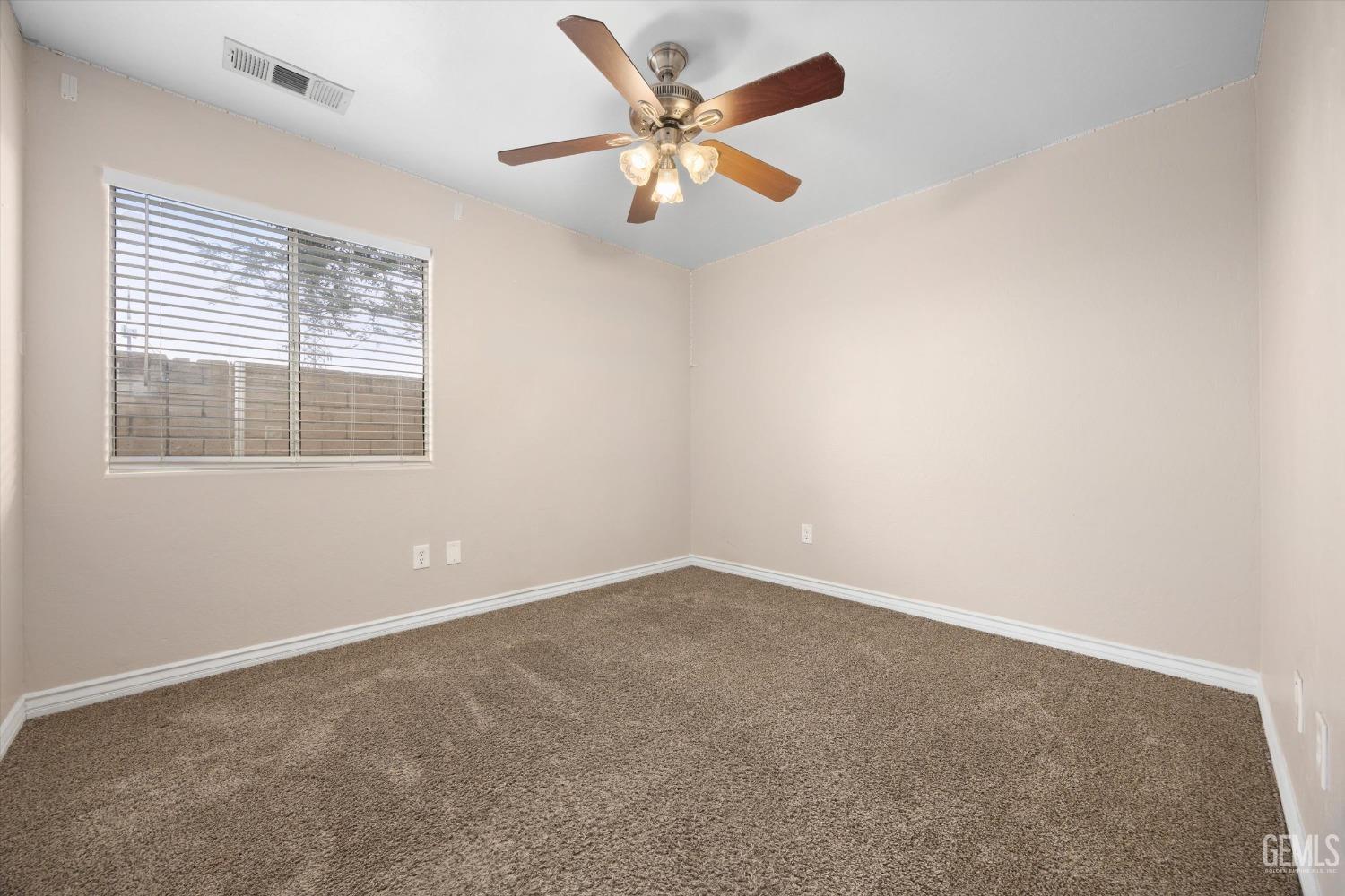 Undisclosed Address Bakersfield, CA 93312 - Photo 26 of 38 an empty room with a window and a ceiling fan