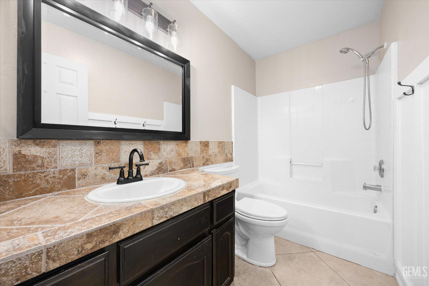 Undisclosed Address Bakersfield, CA 93312 - Photo 28 of 38 a bathroom with a granite countertop sink a toilet a mirror and shower