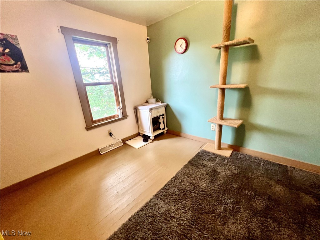 150 Culler Road Weirton, WV 26062 - Photo 15 of 17 Bedroom featuring a wood stove and wood finished floors