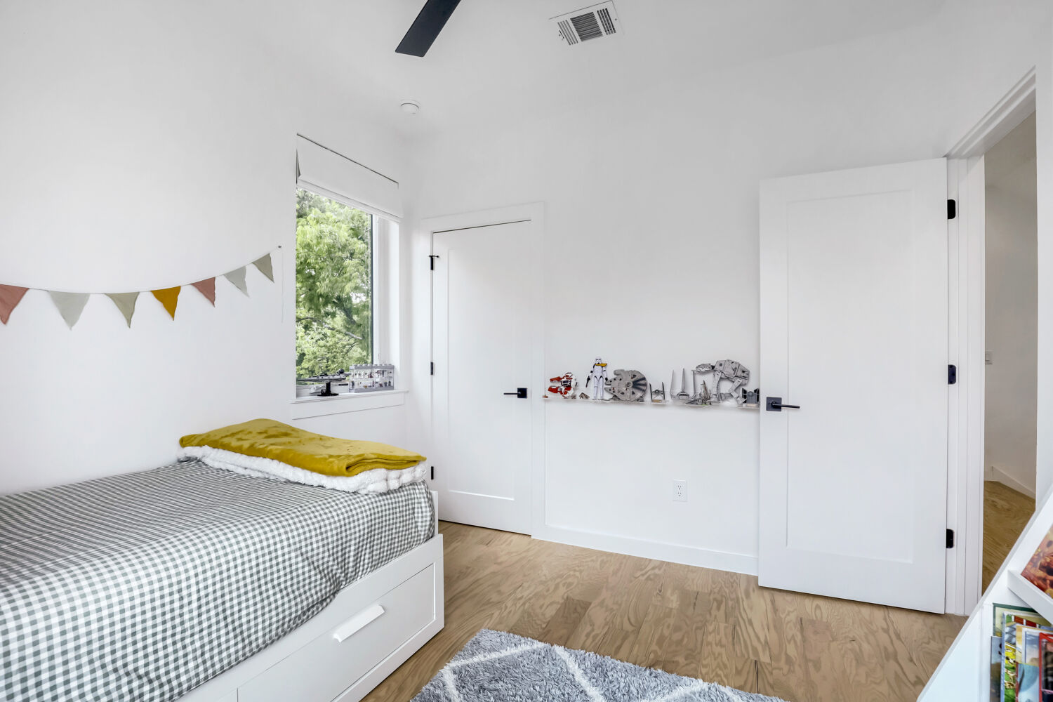 4804 Ribbecke Avenue, Unit A Austin, TX 78721 - Photo 19 of 32 Bright room featuring light wood flooring, white walls, and a window with a view of greenery