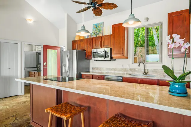 a kitchen with stainless steel appliances granite countertop a refrigerator a stove and a sink
