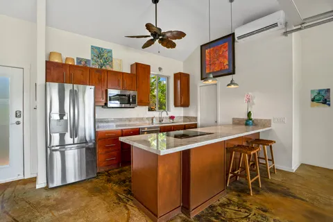 a kitchen with stainless steel appliances granite countertop a sink dishwasher and a refrigerator with wooden floor
