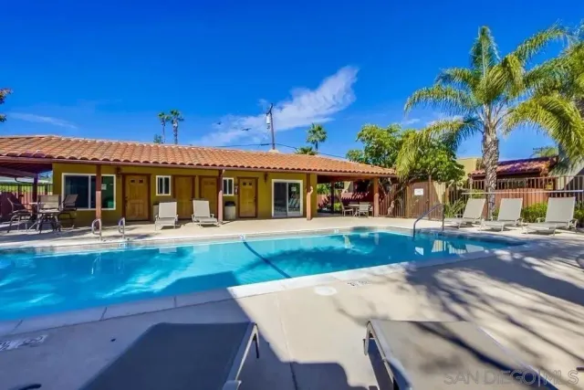 a view of a house with a swimming pool and sitting area