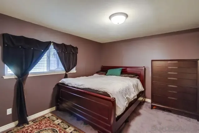 a bed sitting in a bedroom next to a window